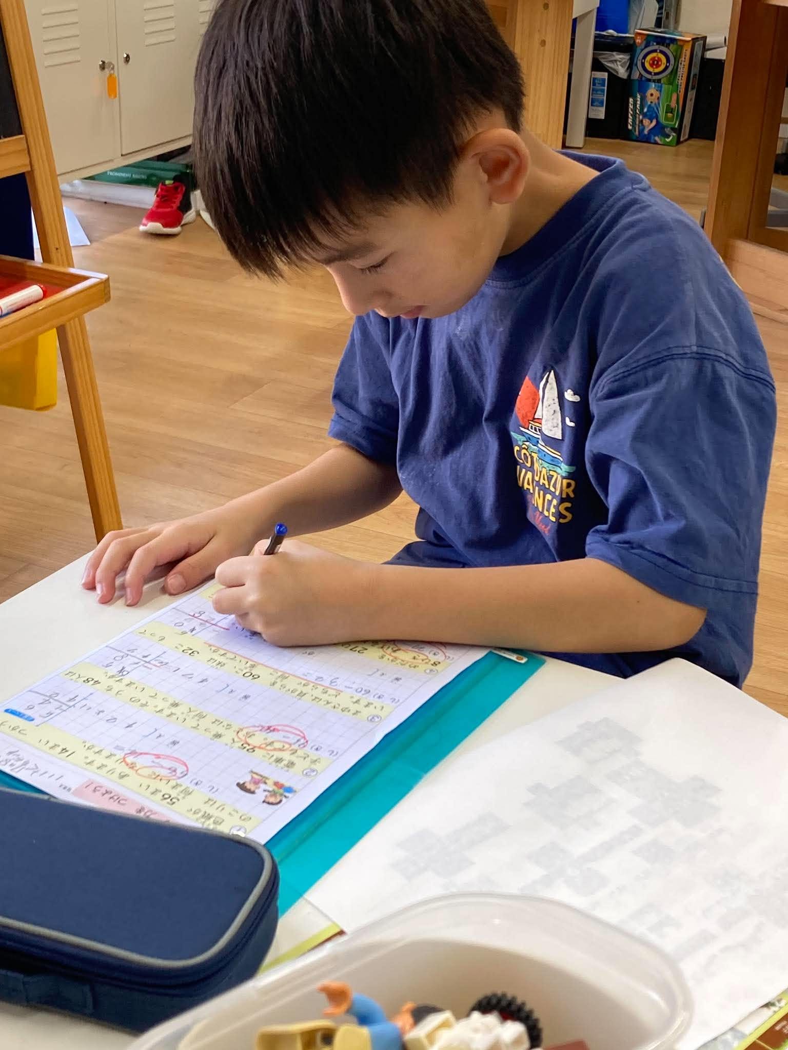 机に向かって学習に取り組む子ども